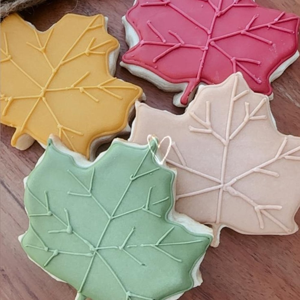 Galletas en forma de hoja de maple glaseadas en mostaza, rojo, crema y verde